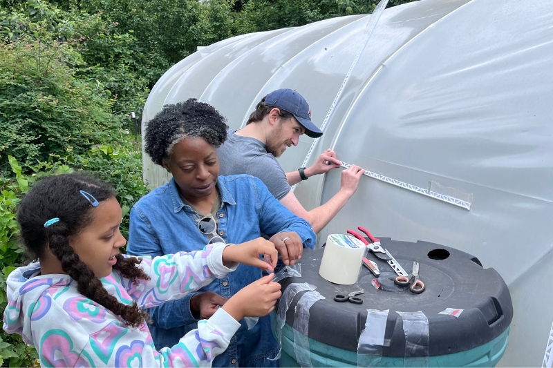Three volunteers work in the garden at Paradise Cooperative