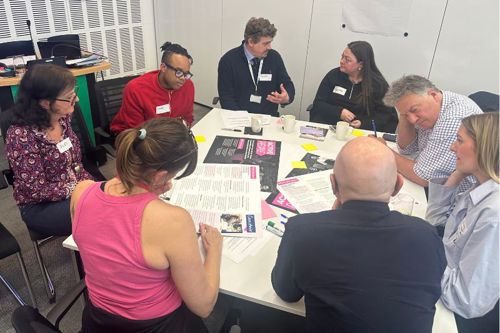 People sat around a table talking to each other and sharing ideas