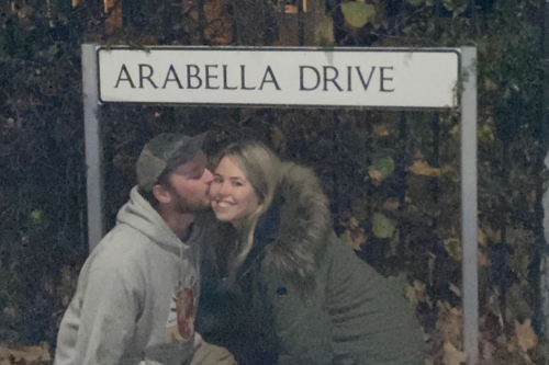 A couple share a kiss under a Wandsworth street sign