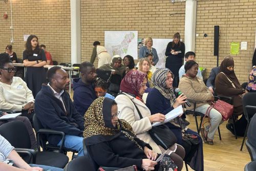 Residents in the audience at the community drop-in asking the Leader questions