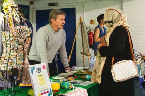 A woman in a headscarf speaks to a stallholder at Wandsworth Sustainability Network